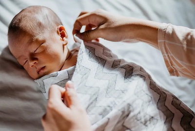 Swaddling is one of the techniques to stop baby from kicking their arms and legs during sleep